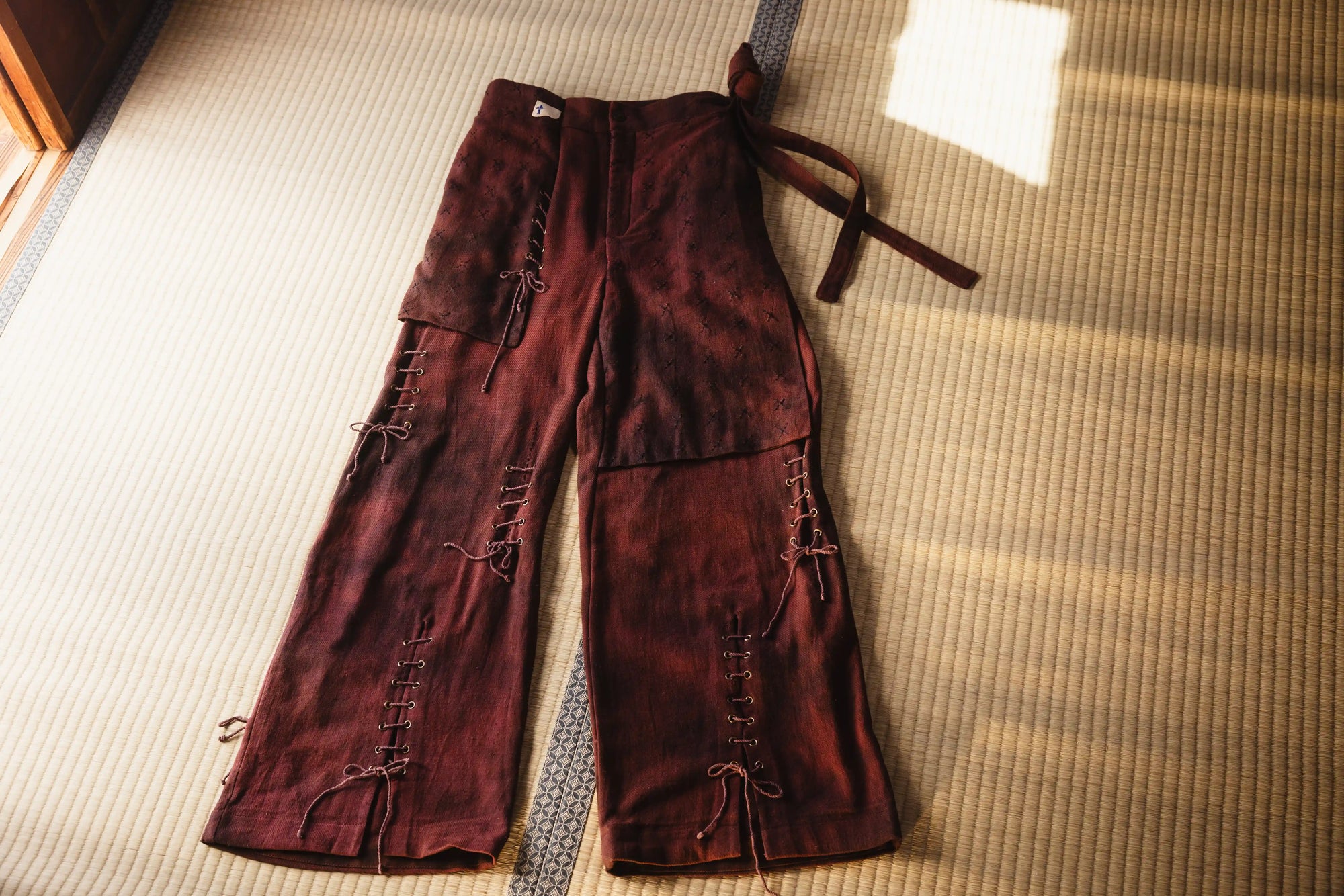 Brown pants with decorative elements on a tatami mat floor